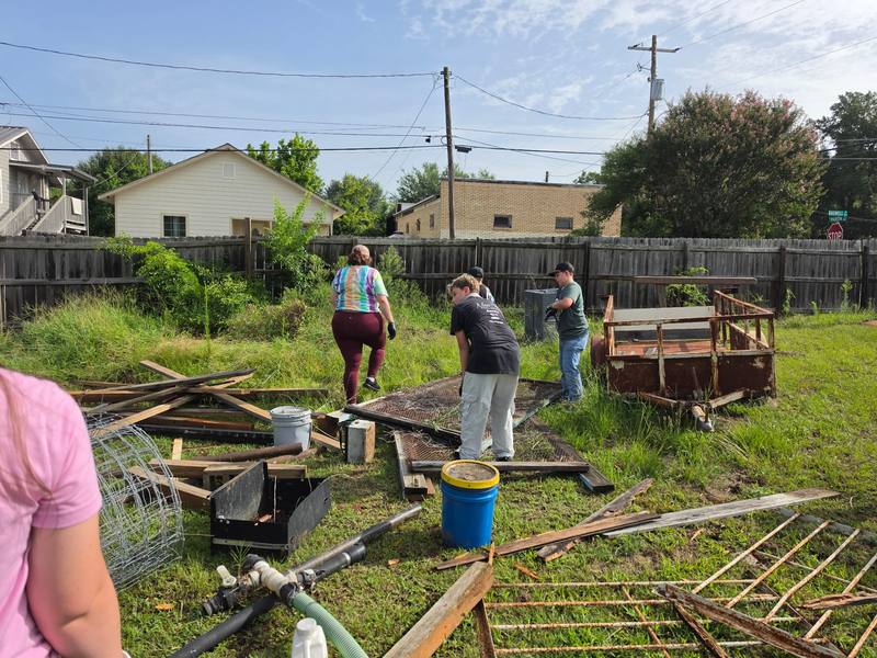 Volunteers sorting materials near a cleanup trailer