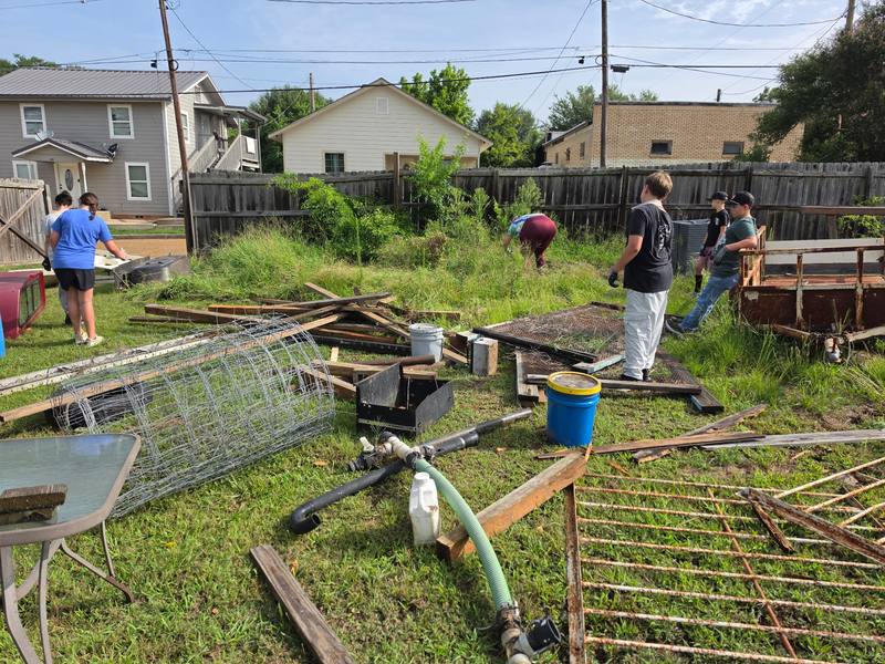 Volunteers clearing debris from an outdoor area