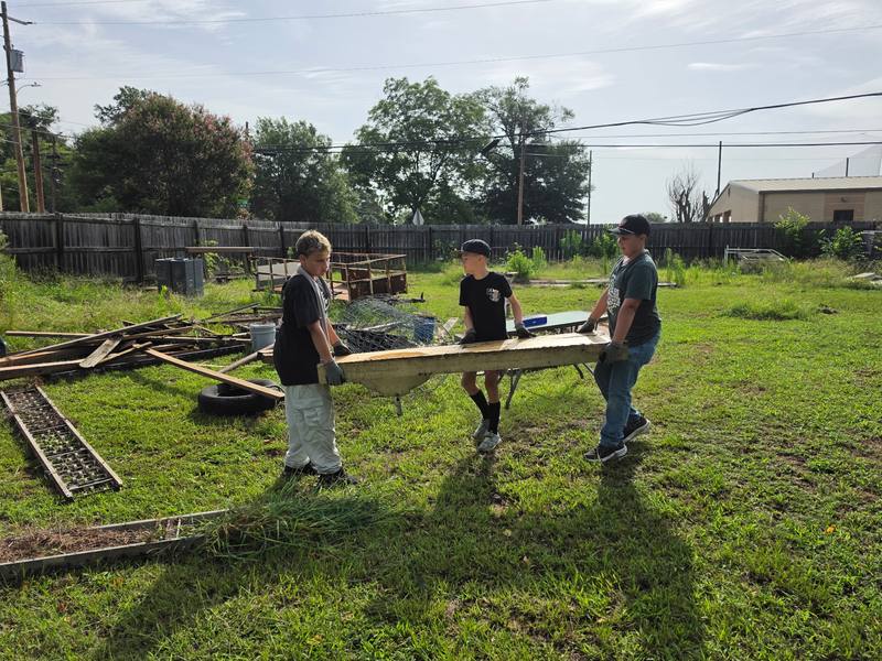 Volunteers carrying cleanup material together